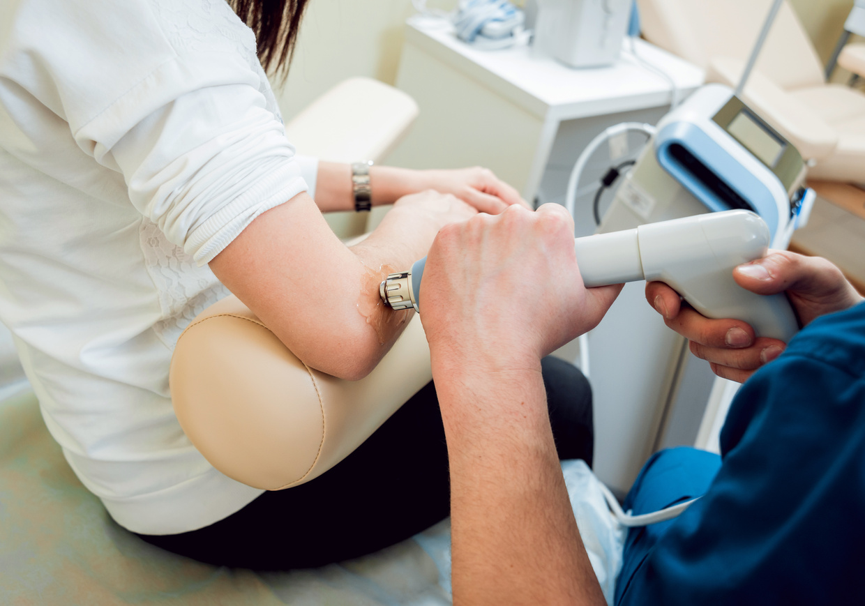 Shock wave therapy. The magnetic field, rehabilitation. Physiotherapist doctor performs surgery on a patient’s elbow